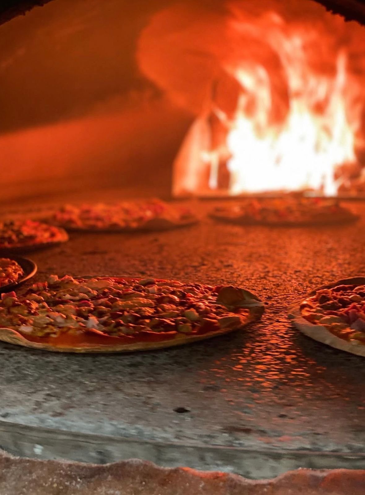 Pizza artesanal saliendo del horno de leña